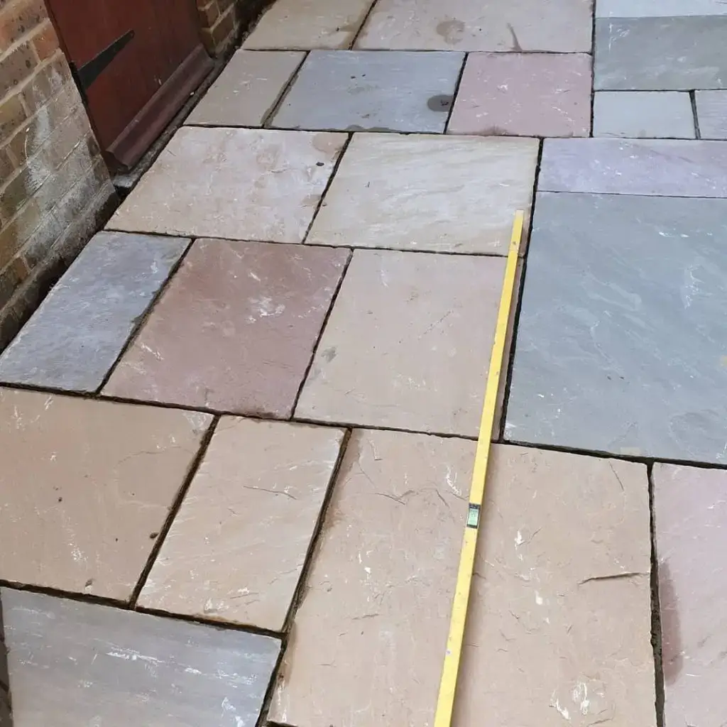 a yellow measuring tape on a marshalls india sandstone patio