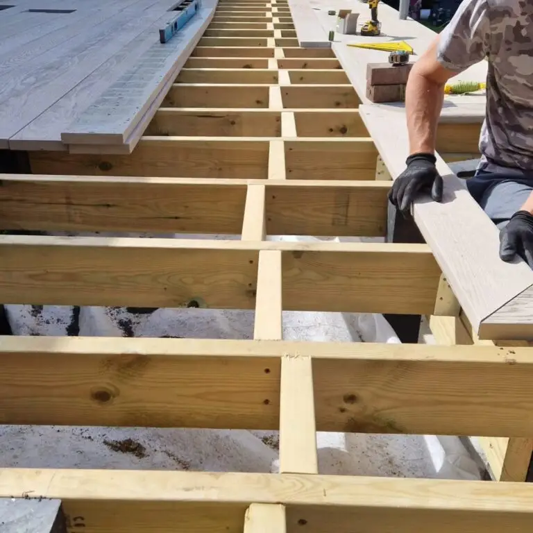 Completed composite decking installation in outdoor garden space showing dark gray composite boards with modern design