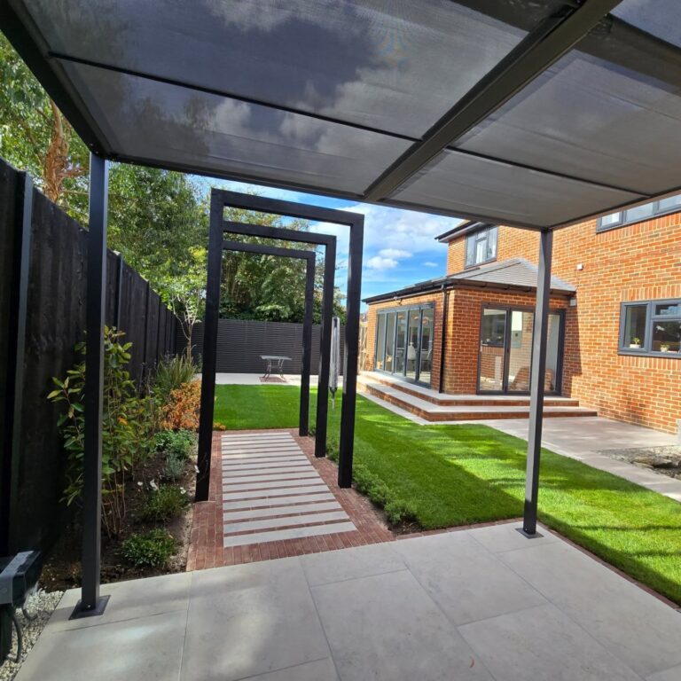 Contemporary pergola frames and stepping-stone walkway leading from a sheltered terrace to the garden lawn